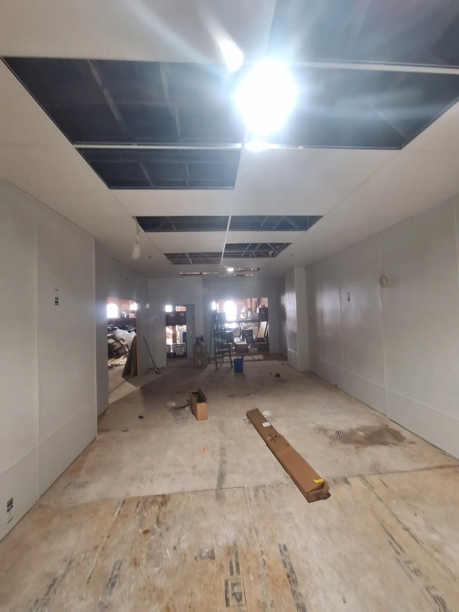 Commercial room with drywall hung and taped and the ceiling grid part-installed